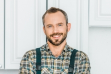 Smiling, bearded man in checkered shirt